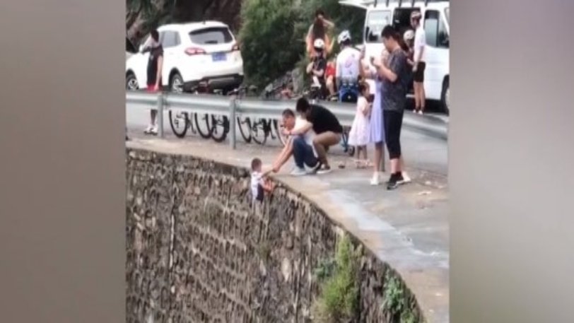 Άντρας κρατάει μικρό αγόρι σε γκρεμό για να βγάλει φωτογραφία